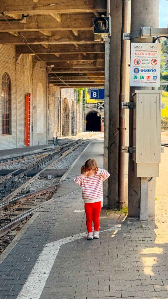 A toddler stands waiting at the Montreux train station.